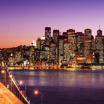 San Francisco skyline at dusk with Bay Bridge – business class flights from San Francisco to New York available now.