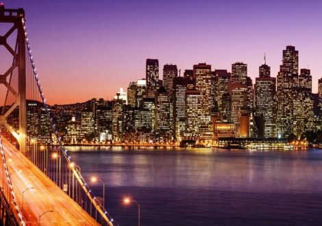 San Francisco skyline at dusk with Bay Bridge – business class flights from San Francisco to New York available now.